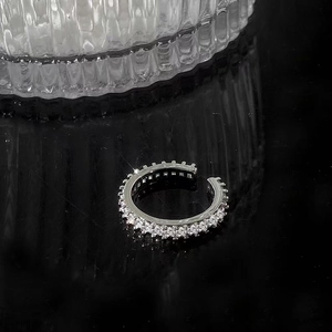 Detail of silver ear cuff with paved white zircon stones and minimalist C-shaped design