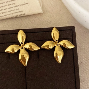 Elegant gold metal petal stud earrings with four textured leaves on velvet display