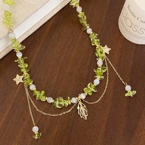 Bohemian necklace with green peridot stones, white beads and gold star pendants
