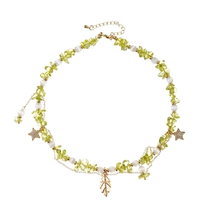 Bohemian light green stone necklace with golden leaf and star charms on white background