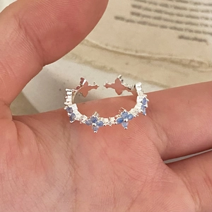 Elegant adjustable silver ring with light blue four-petal flower zircon stone on model