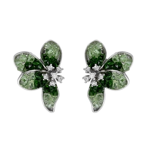 Macro detail of silver flower earrings with green crystal petals and sparkling clear rhinestones