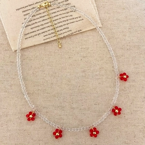 Elegante Perlenkette mit weißen Kristallen und kleinen roten Blumenanhängern für Damen