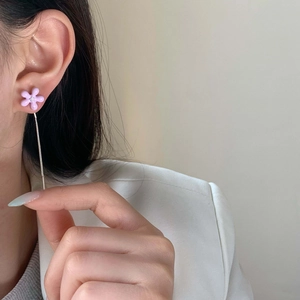Sweet purple flower drop earrings with long silver tassel worn on a female model