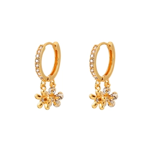 Détail de boucles d'oreilles fleurs dorées avec cristaux et détails micro-pavé