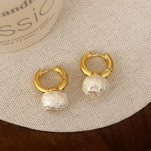 Elegant gold hoop earrings featuring unique white textured baroque-style pearl drops