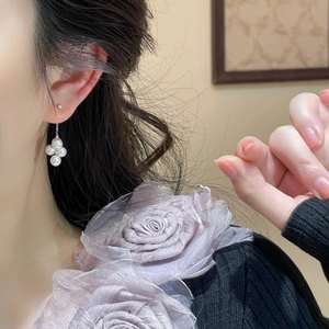 Elegant floral cluster pearl earrings with 925 silver needles worn by a model