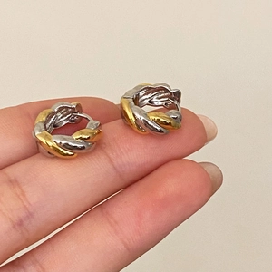 Twisted two-tone gold and silver hoop earrings featuring a chic woven metal design