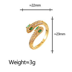 Detailed view of gold snake ring with white zircon pave and green stone eyes