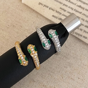 Elegant gold and silver snake rings with white zircon pave and green gem eyes for women