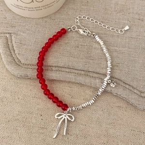 Elegant natural stone bracelet with red beads, silver bow pendant, and crystal charm
