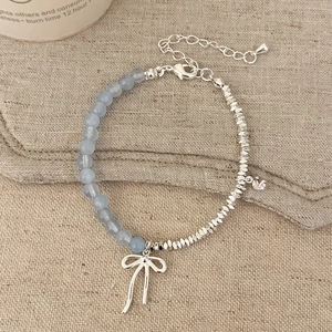 Dual-strand natural stone bracelet with blue beads, metal cubes and bow pendant