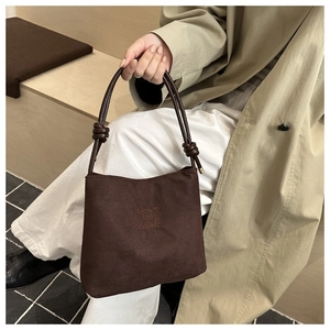 Détail du sac en velours côtelé marron foncé avec broderie 'fashion and classic' et anses nouées