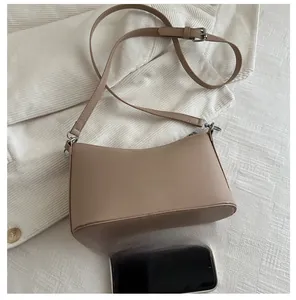 Close-up of beige bucket bag next to a smartphone for size comparison and reference