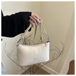 Détail du sac à épaule en cuir ivoire avec fermeture éclair et bandoulière réglable