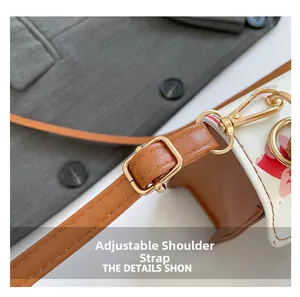 Detail view of adjustable brown strap with gold metal buckle on printed crossbody bag