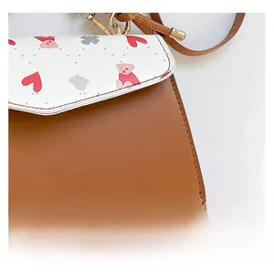 Detailed view of high-quality leather stitching and cute cartoon bear print on handbag