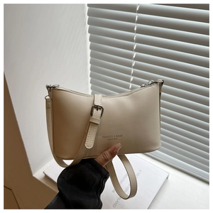Détail du sac à épaule en cuir crème montrant le texte mode et les pièces en argent