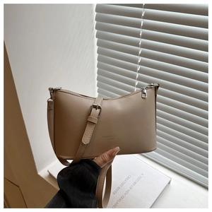 Vue détaillée du sac à bandoulière beige avec boucle métallique et logo en relief