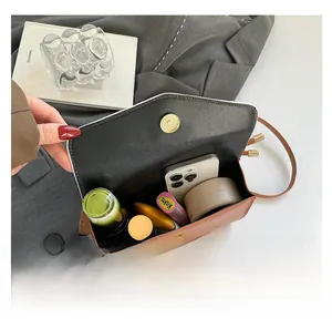 Internal view of a brown vintage crossbody bag showing ample capacity for cosmetics
