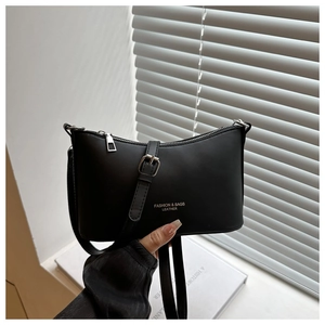 Gros plan sur le sac baguette noir avec boucles argentées et bandoulière réglable