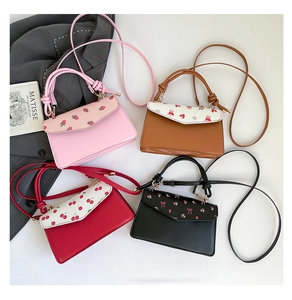 Flat lay of colorful printed PU leather crossbody bags with knotted handles and flap covers