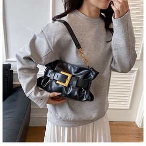 Detail of black pleated cloud bag with large gold buckle and chunky chain strap