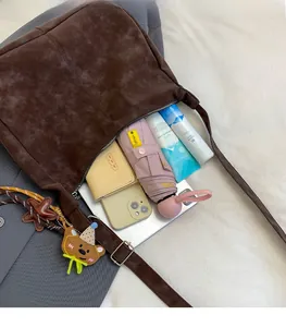 Spacious dark brown tote bag interior filled with everyday essentials and a bear charm