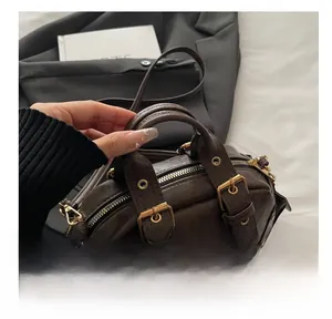 Detail of vintage brown oil-wax leather handbag with golden buckles and metal zipper