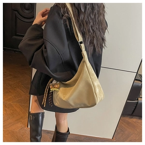 Detail view of khaki hobo shoulder bag with a bear charm showing its large capacity