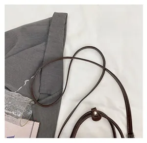 Detail of the soft round shoulder strap and stitching on a brown leather tote bag