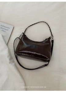 Detail shot of the glossy dark brown faux leather tote with metallic chain shoulder strap