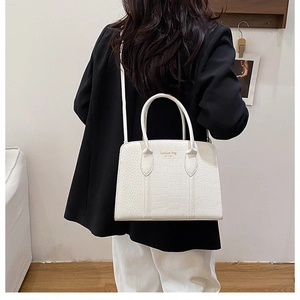 Minimalist white crocodile-textured tote bag shown as a crossbody on a female model