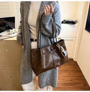 Detalle de bolso tote de cuero marrón oscuro con cuentas vintage y hebilla de metal