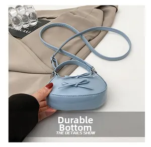 Close-up of the wear-resistant bottom on this light blue bow detail crossbody bag