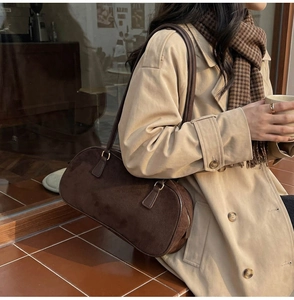 Deep brown suede shoulder bag styled with an autumn trench coat in a cozy cafe setting