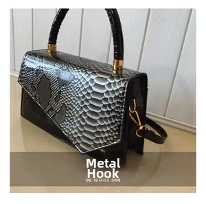 Detail of hardware hook and snake pattern patchwork on stylish lady's crossbody bag
