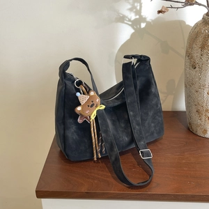 Classic black matte crescent Hobo bag with a cute bear charm on a wide shoulder strap