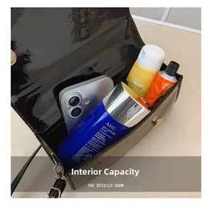 Internal capacity view of black patent leather square bag showing spacious storage