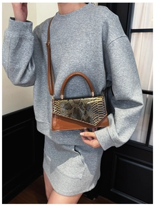 Detail of caramel faux snake skin texture and glossy finish on a stylish square bag