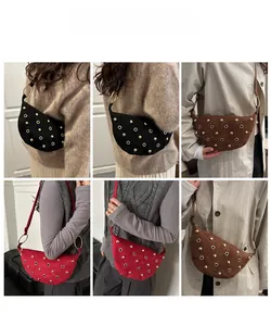 Détail du sac bandoulière en daim avec œillets métalliques et rivets en trois couleurs