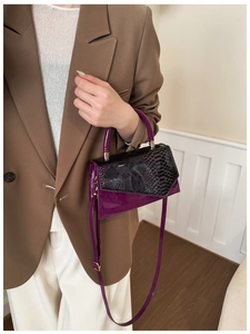 Fashionable crossbody bag featuring purple patent leather and black snake pattern texture