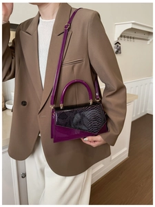 Detail of purple patent leather shoulder bag with snake skin flap and round handle