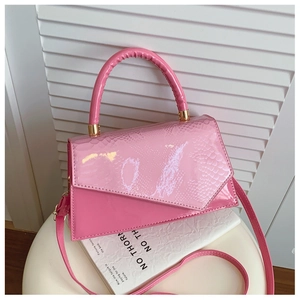 Detail of pink embossed patent leather bag with snakeskin texture and gold hardware