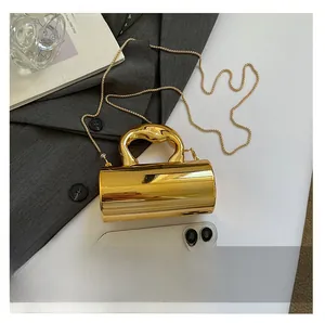 Detailed comparison of a metallic gold cylinder bag next to a smartphone for size scale