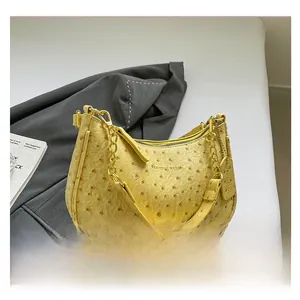 Dettaglio borsa gialla in pelle testurizzata struzzo con catena d'oro e tracolla