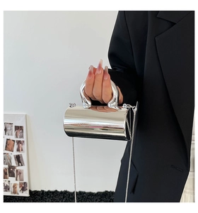 Macro shot of futuristic silver mirror cylinder handbag with sleek metal handle and chain