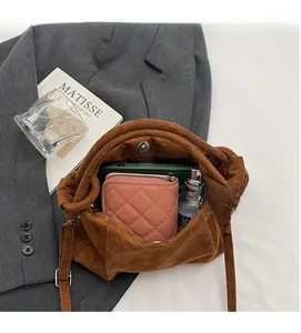 Vue détaillée du sac seau en daim marron montrant son compartiment intérieur spacieux