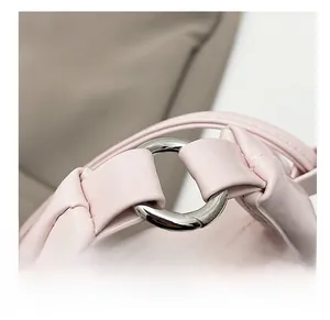 Dettaglio macro dell'anello d'argento e tracolla in pelle a pieghe della borsa rosa