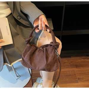 Détail du sac à main plissé marron foncé avec poignée torsadée et bandoulière amovible